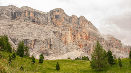 Naklejka na ściany i meble East face of Sasso di Santa Croce mountain range in the eastern Dolomites, its 900 meters vertical wall and Mount Cavallo, seen from Roda de Armentara trail to St. Croce refuge, South Tyrol, Italy