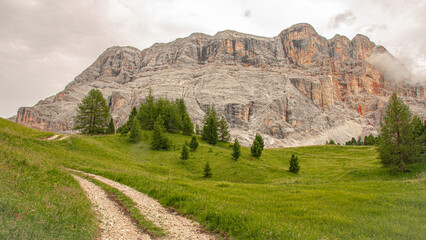 Fototapeta na wymiar East face of Sasso di Santa Croce mountain range in the eastern Dolomites, its 900 meters vertical wall and Mount Cavallo, seen from Roda de Armentara trail to St. Croce refuge, South Tyrol, Italy
