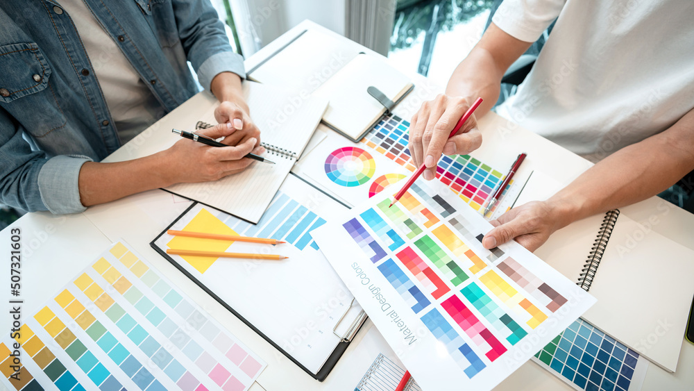 Poster Two creative graphic designer team working on color selection and drawing on graphic tablet, Color swatch samples chart for selection coloring in inspiration to creativity at workplace
