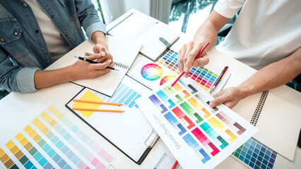 Two creative graphic designer team working on color selection and drawing on graphic tablet, Color...