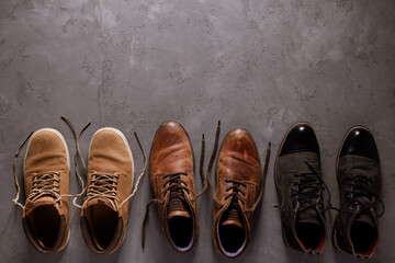 Old leather boots on  cement floor background texture. Old shabby boot shoes