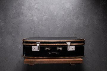 Vintage suitcase on wood shelf at wall. Old vintage suitcase