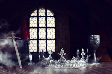 low key image of beautiful queen or king crown next to sword. fantasy medieval period. Selective...