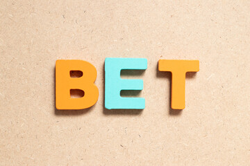 Color alphabet letter in word bet on wood background