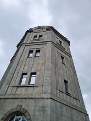 Fototapeta na wymiar Gray tower with windows under a gray rainy sky