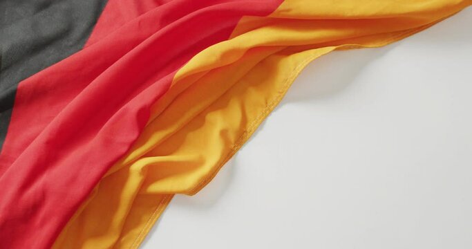 Video of creased flag of germany lying on white background