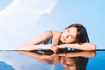 Beauty portrait with water of young woman fashion model with healthy dark long hair on blue...