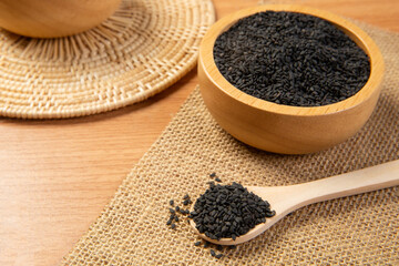 Black sesame in wooden spoon and bowl,close up and choose a focus point.