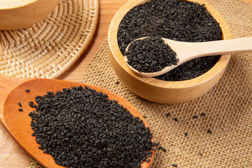 Black sesame in wooden spoon and bowl,close up and choose a focus point.