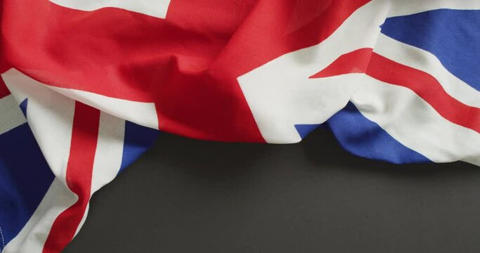 Video of creased flag of great britain lying on white background