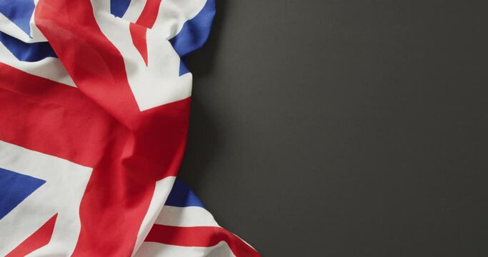 Video of creased great britain flag lying on black background