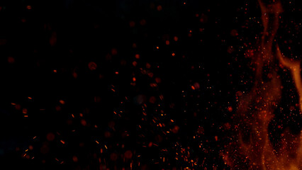 Fire sparks flying like particles on black background.