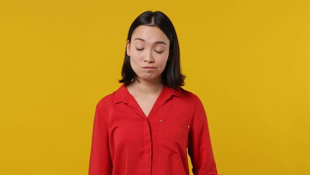 Boring dull young woman of Asian ethnicity 20s years old wears red shirt take use mobile cell phone read search find good news gets excited happy isolated on plain yellow background studio portrait