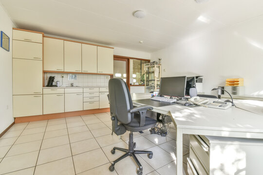 Office equipment on tables in spacious workplace and kitchen