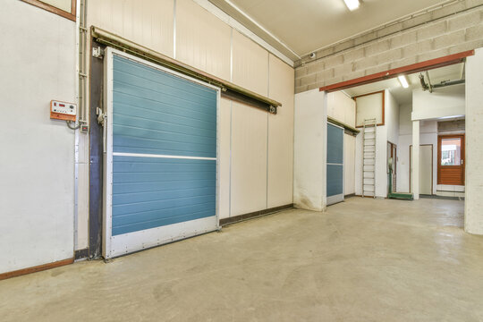 Spacious corridor of storehouse with blue metal doors