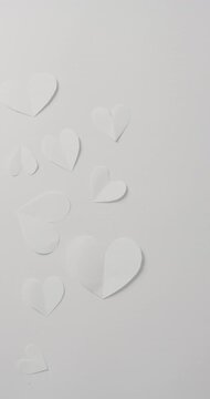 Vertical video of close up of paper hearts