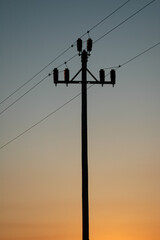 silhouette of a power pole at sunset in the desert