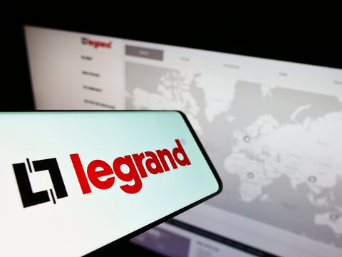 Stuttgart, Germany - 05-21-2022: Smartphone with logo of French electronics company Legrand SA on screen in front of business website. Focus on center-right of phone display.