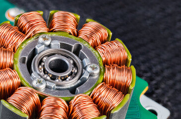 Electric engine stator with coils copper wire winding or ball bearing on green PCB detail. Closeup...