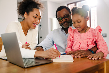 African american family with girl drawing in notepad at home