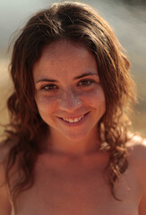 a young girl smiling and looking at the camera naked