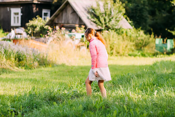 A little girl walks in the contryside in summer day.