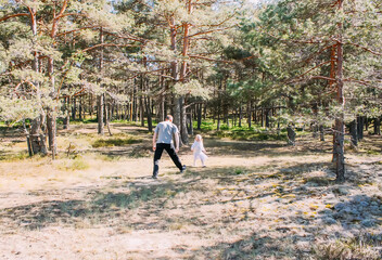 Fototapeta premium Father and daughter playing in a spring forest. Active people are having a good time outdoors