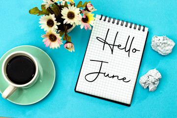hello June concept on notebook with crash papers and roses flowers and cup of coffee isolated on blue  - Powered by Adobe