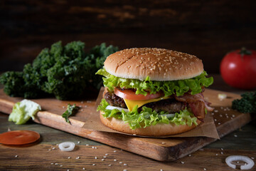 Homemade hamburger with cheese on a wooden cutting board