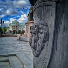 The black figure of a lion on a pillar in front of the city