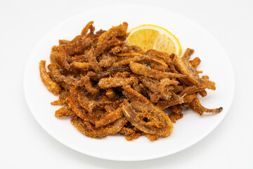 Crispy Pig Ears with Lemon on a White Plate