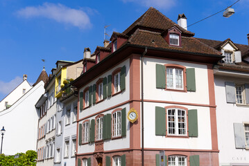 Fototapeta na wymiar Medieval old town of City of Basel with beautiful historic houses and house named Zum Grabeneck 1776 with golden clock on a blue cloudy spring day. Photo taken April 27th, 2022, Basel, Switzerland.