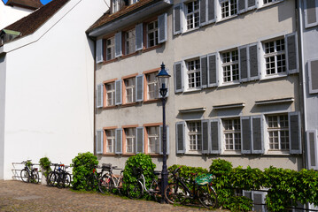 Medieval old town of City of Basel with beautiful historic houses and parked bicycles on a blue cloudy spring day. Photo taken April 27th, 2022, Basel, Switzerland.