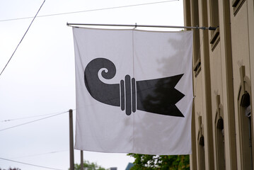 Armory at City of Basel with flag of City and Canton Basel Stadt on a cloudy spring day. Photo taken April 27th, 2022, Basel, Switzerland.