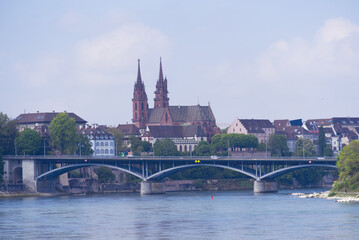 Skyline of the old town of Basel with Basler Minster and Wettstein Bridge in the foreground on a blue cloud spring day. Photo taken April 27th, 2022, Basel, Switzerland.