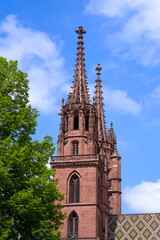 Fototapeta na wymiar Twin tower of medieval church Basler Minster at the old town of Basel on a blue cloudy spring day. Photo taken April 27th, 2022, Basel, Switzerland.