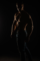 Fototapeta na wymiar Silhouette of topless guy posing and twisting