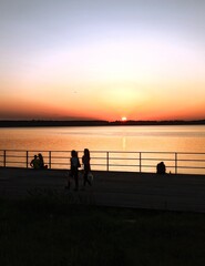 People on the embankment admiring the sunset.