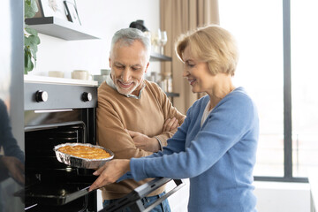 Middle aged couple baking apple pie together