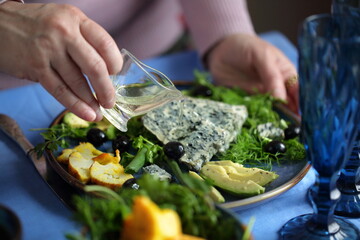 Cheese with avocado, olives and cauliflower on a blue plate