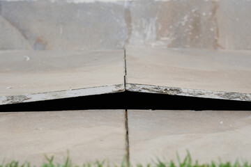 Selective focus picture of tiles lifted and  broken at the floor