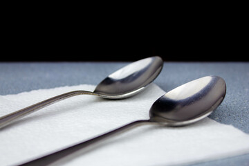 Small spoons on a napkin. Dessert spoons. Metal spoons. Tea dessert spoons. Silver spoons.