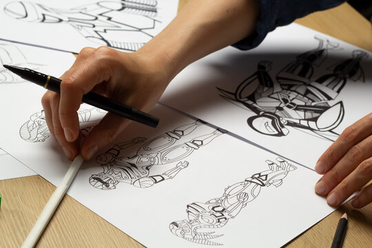 The illustrator draws sketches of robot computer game characters. The artist creates a design of cyborgs. Concept art.