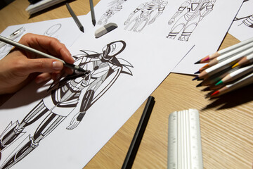 The illustrator draws sketches of robot computer game characters. The artist creates a design of...