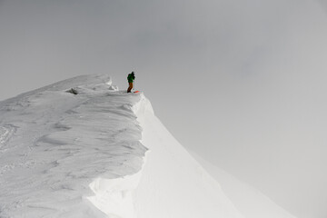 Great view on skier in bright jacket with on splitboard on mountain at winter day