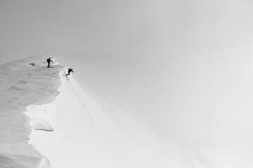 Great view of freeriders on splitboard riding down from top of ridge.