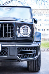 front view of the headlight of a large black powerful prestigious car