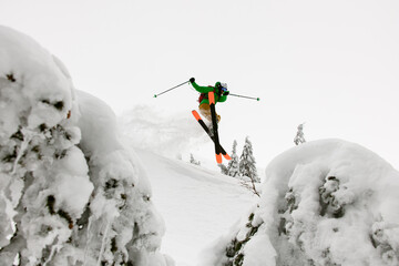 great view of athlete skier jumping over slopes of snow-capped mountains - obrazy, fototapety, plakaty