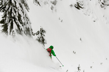 Snowboarder riding down in avalanche track terrain during as part of fun, extreme, splitboard