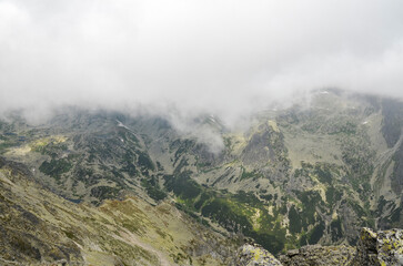 Fog and clouds over high peaks of mountain ridge in National Park High Tatras Mountains, Slovakia 